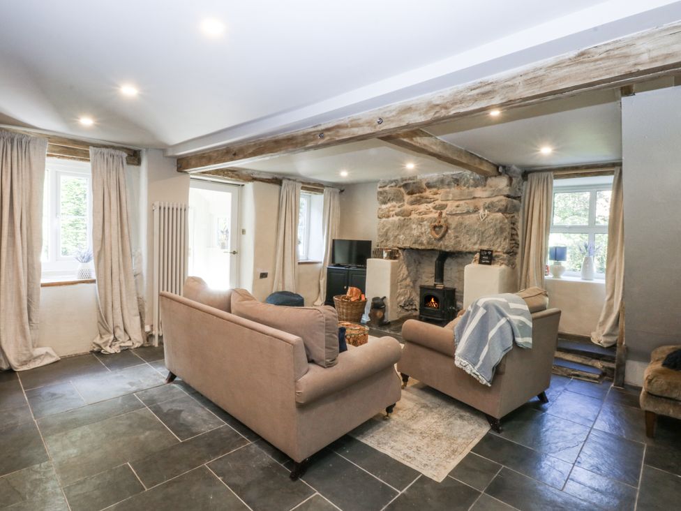 A living room with a sofa and a fireplace at Islwyn, Llanuwchllyn near Bala