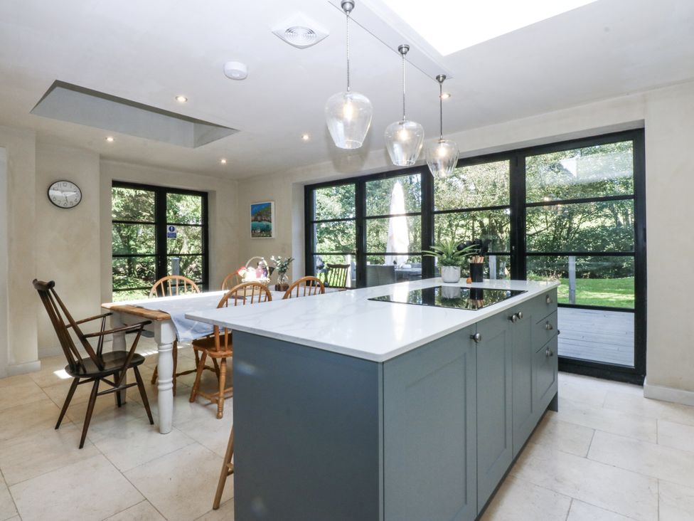 A kitchen with an island and dining table at Islwyn Llanuwchllyn near Bala