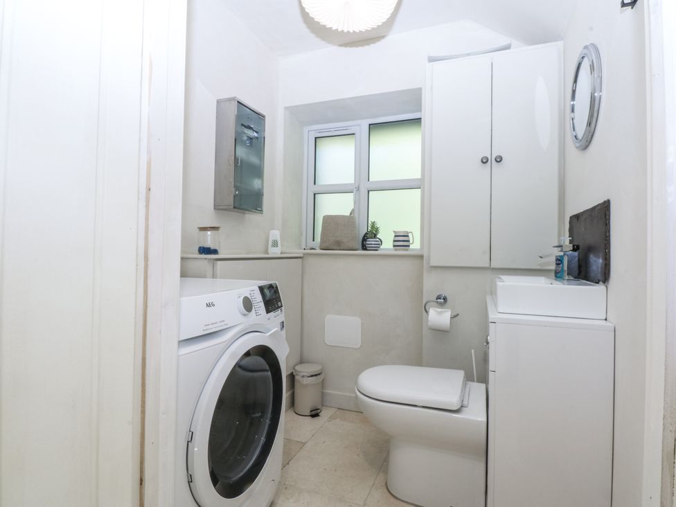 A bathroom with a washing machine and toilet at Islwyn Llanuwchllyn near Bala