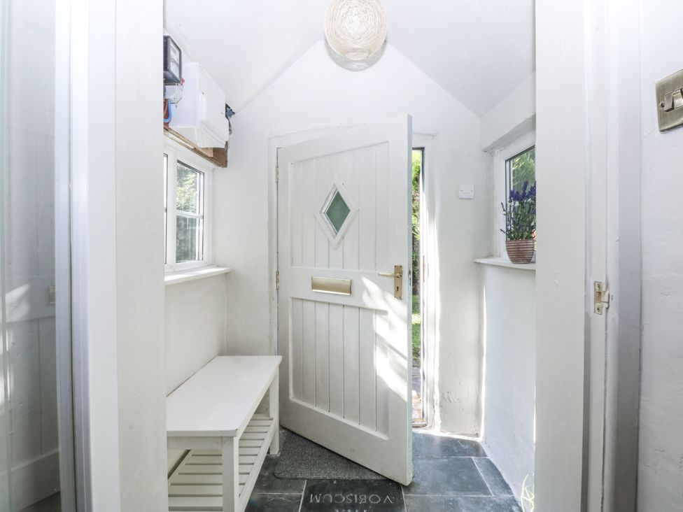 An entrance hall with a white door and bench at Islwyn in Llanuwchllyn near Bala