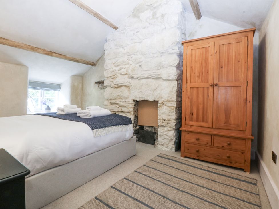 A bedroom with a bed and wardrobe at Islwyn in Llanuwchllyn near Bala