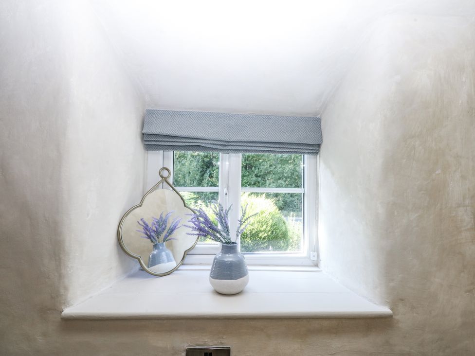A window with a flower vase and a mirror at Islwyn in Llanuwchllyn near Bala