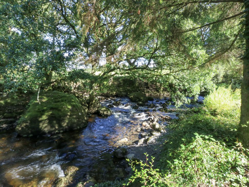A river flowing beside rocks and trees at Islwyn in Llanuwchllyn near Bala