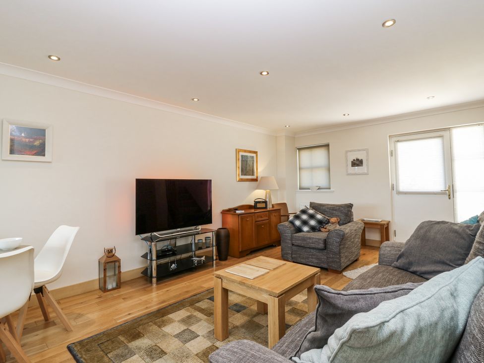 A living room with a sofa and television at 6A Pitlethie Steading in Leuchars