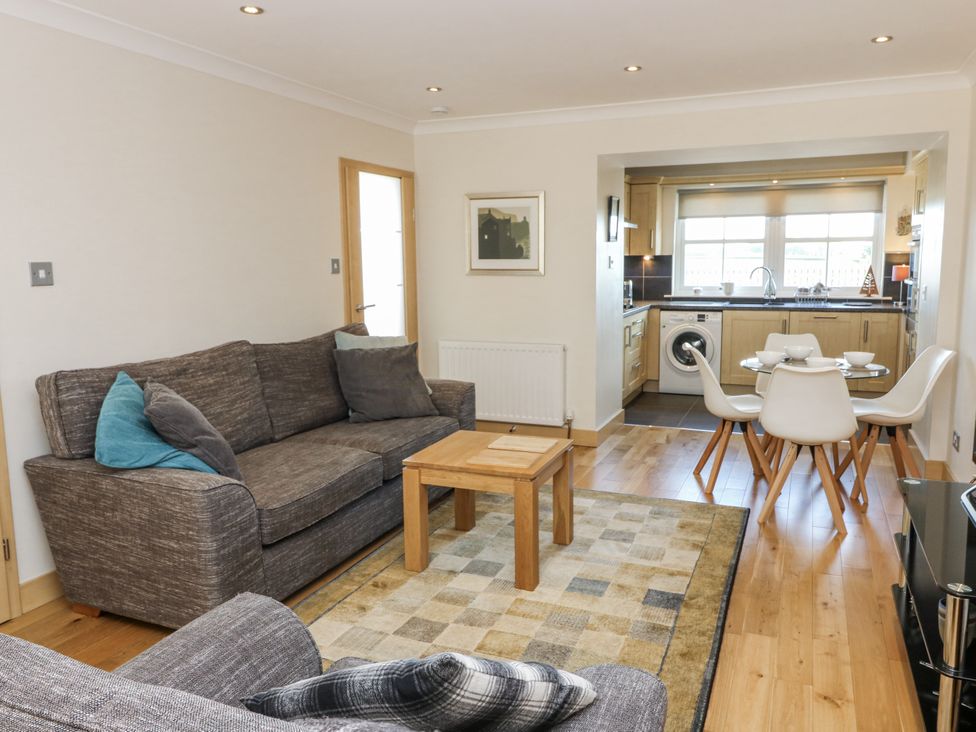 A living room with a sofa and dining table at 6A Pitlethie Steading Leuchars