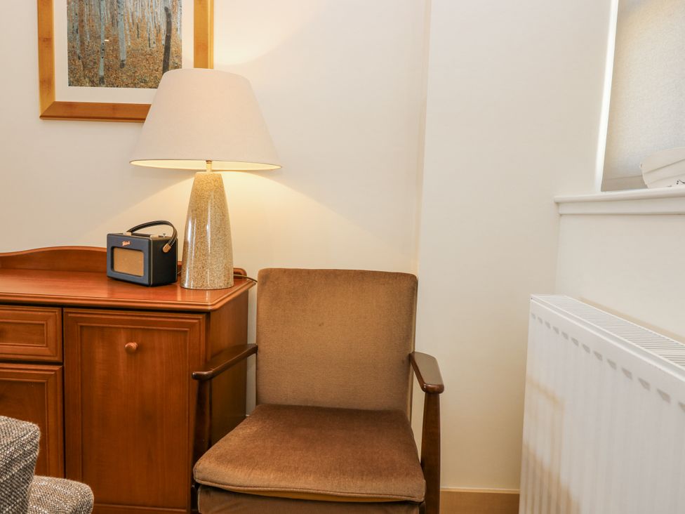 A chair and lamp next to a table with a radio at 6A Pitlethie Steading Leuchars