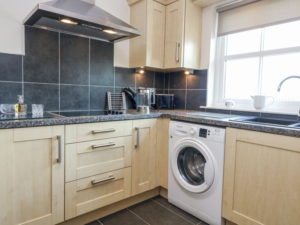A kitchen with a washing machine and a stove at 6A Pitlethie Steading, Leuchars