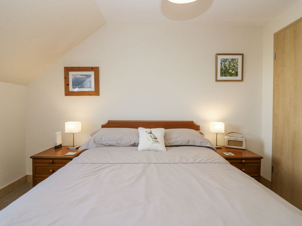 A bedroom with a bed and bedside tables at 6A Pitlethie Steading Leuchars