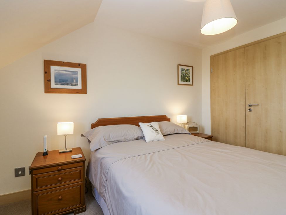 A bedroom with a bed and nightstand at 6A Pitlethie Steading Leuchars