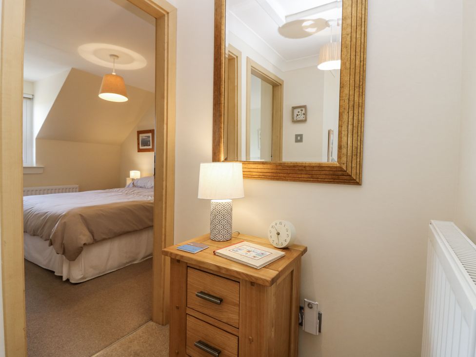 A hallway with a mirror and table at 6A Pitlethie Steading in Leuchars