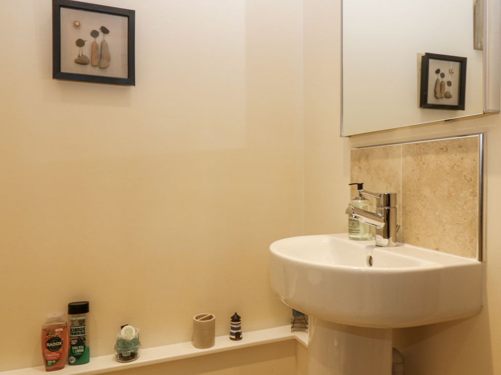 A bathroom with a sink and mirror at 6A Pitlethie Steading Leuchars