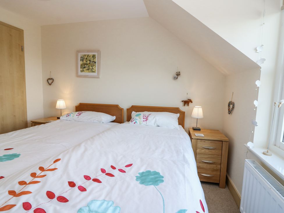 A bedroom with two beds and side tables at 6A Pitlethie Steading Leuchars