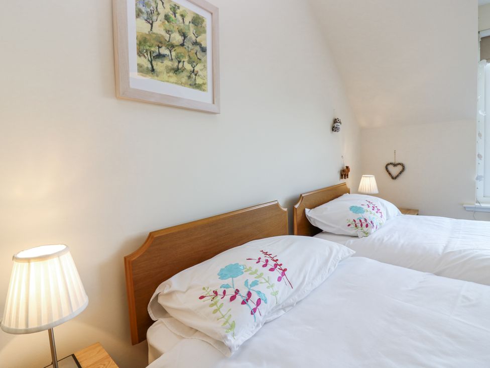 A bedroom with two beds and a picture frame at 6A Pitlethie Steading Leuchars