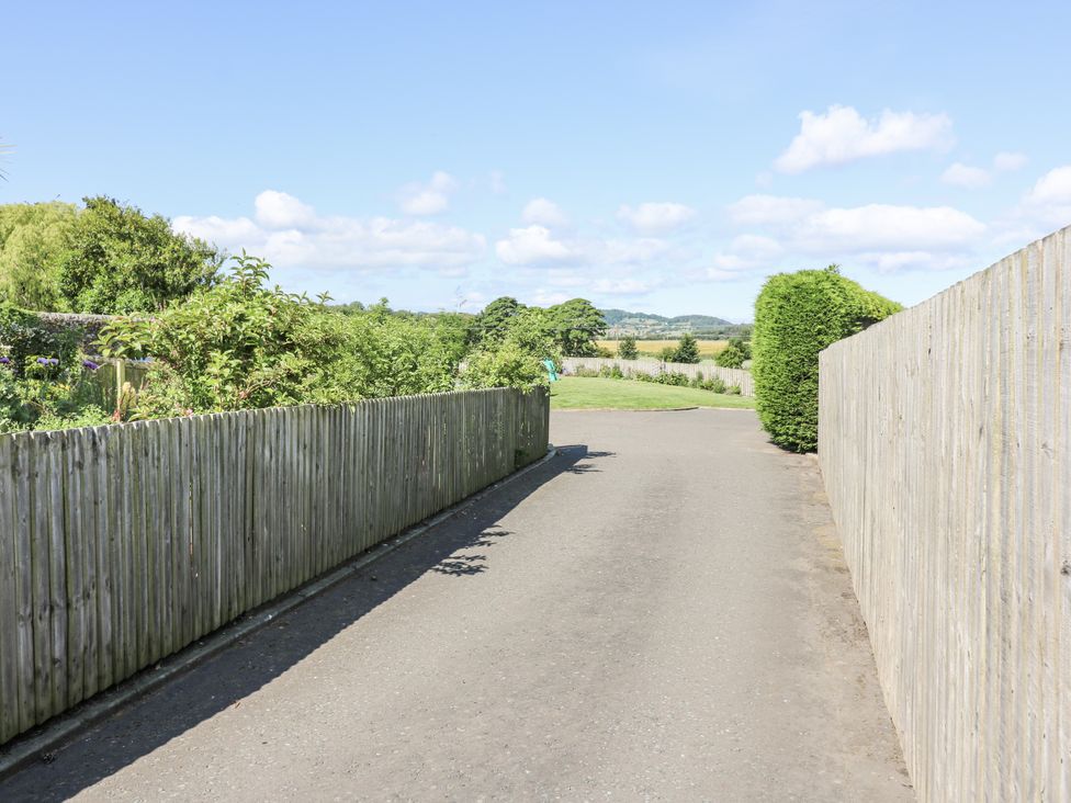 A driveway with wooden fence and greenery at 6A Pitlethie Steading Leuchars