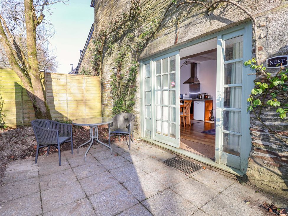 An outdoor patio with a table and chairs at Nest Cottage in St Tudy