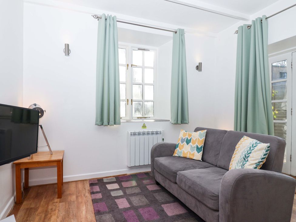 A living room with a television and a sofa at Nest Cottage in St Tudy