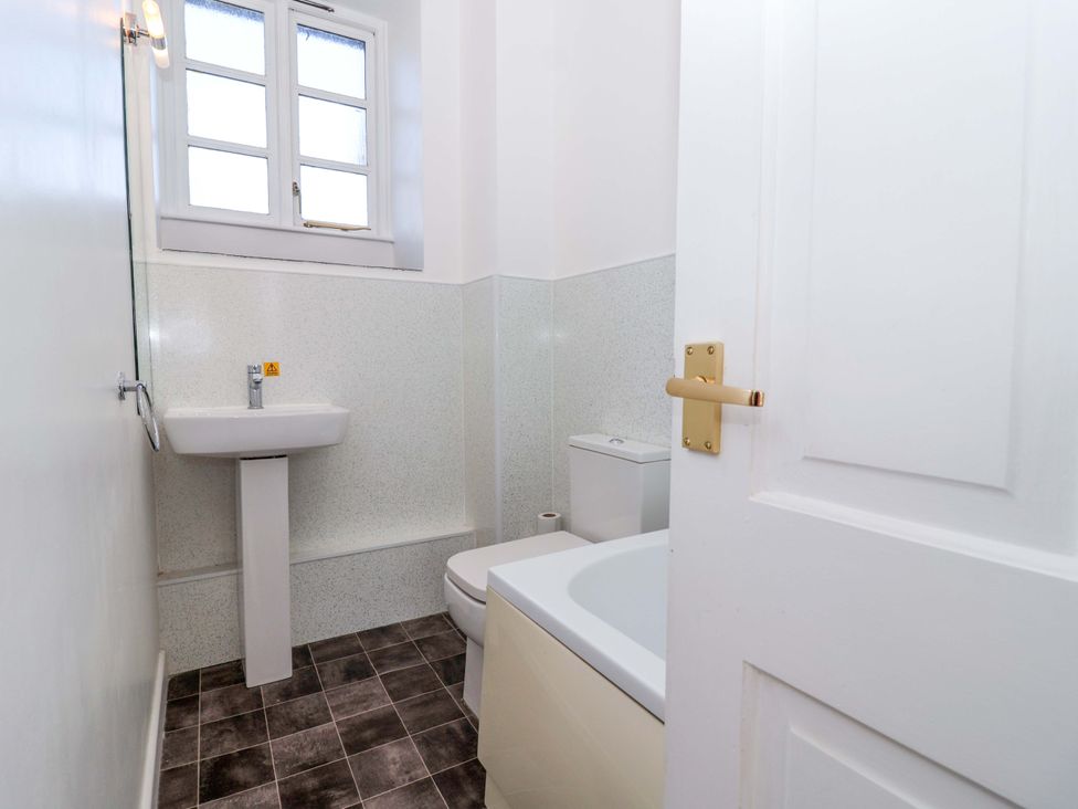 A bathroom with a sink, toilet, and bathtub at Nest Cottage in St Tudy