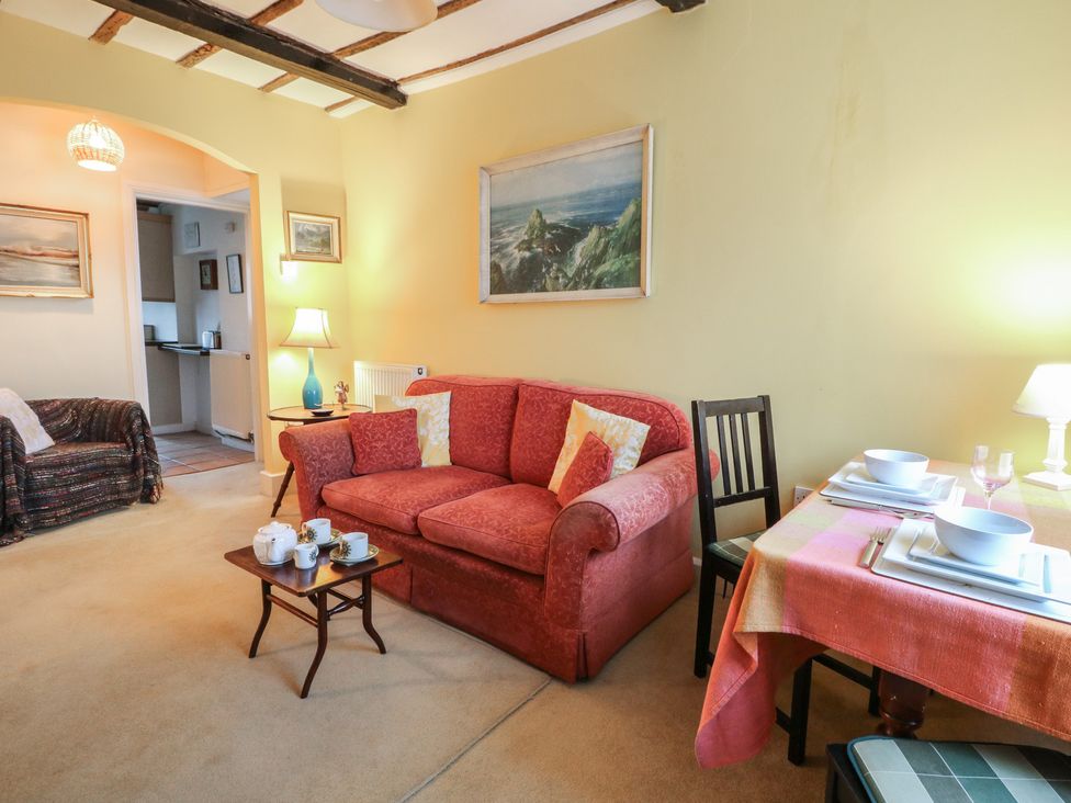 A living room with a sofa and dining table at 6 Church Lane Llanidloes
