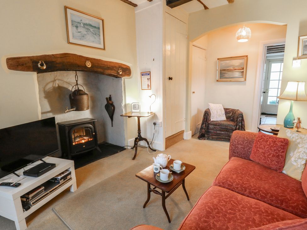 A living room with a sofa, table, and television at 6 Church Lane, Llanidloes