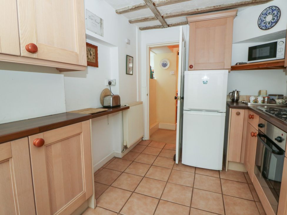 A kitchen with cabinets and appliances at 6 Church Lane in Llanidloes