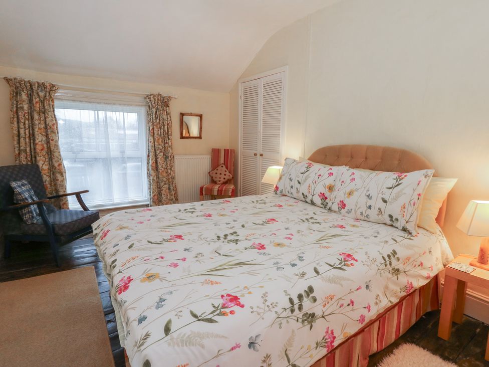 A bedroom with a bed and chair at 6 Church Lane Llanidloes