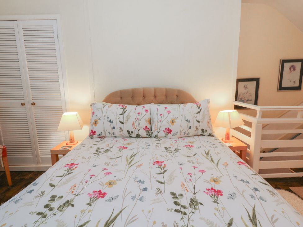 A bedroom with a bed and nightstands at 6 Church Lane Llanidloes