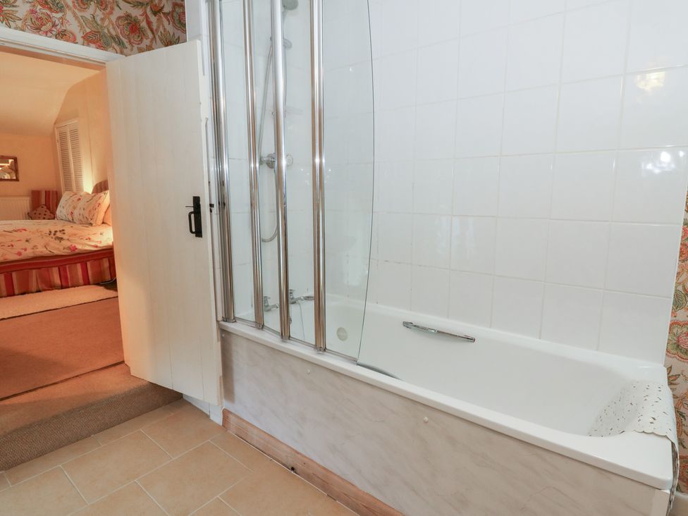A bathroom with a shower and bathtub at 6 Church Lane Llanidloes