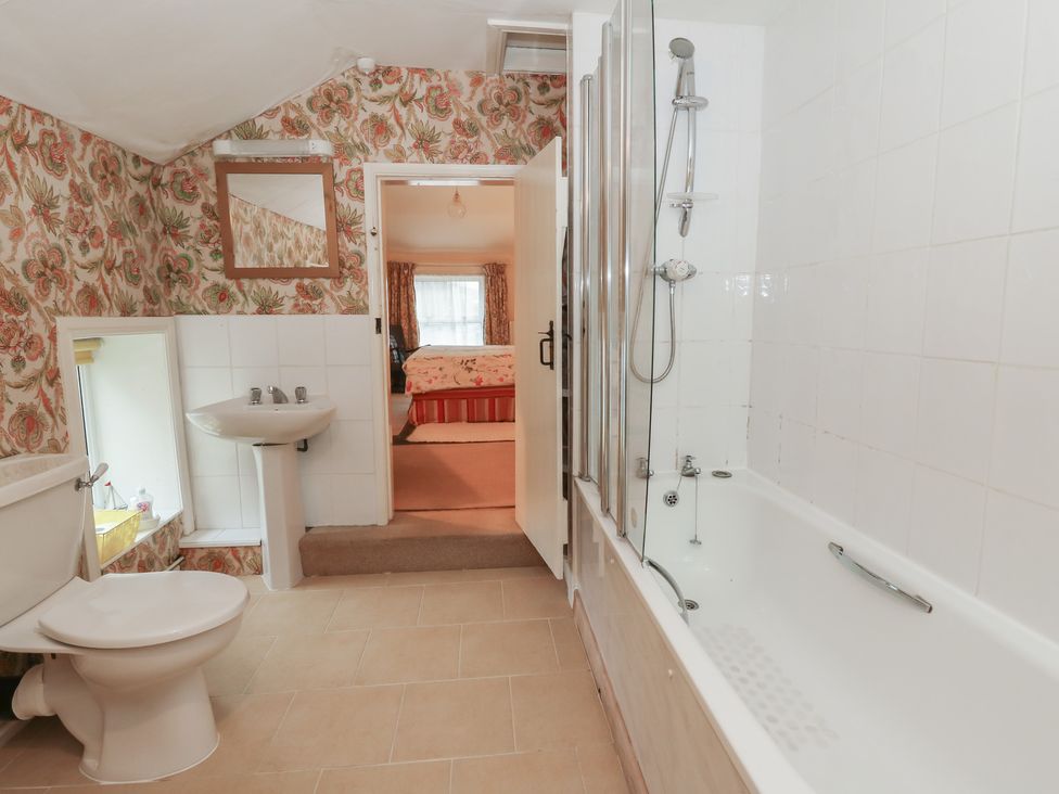 A bathroom with a bathtub and sink at 6 Church Lane Llanidloes