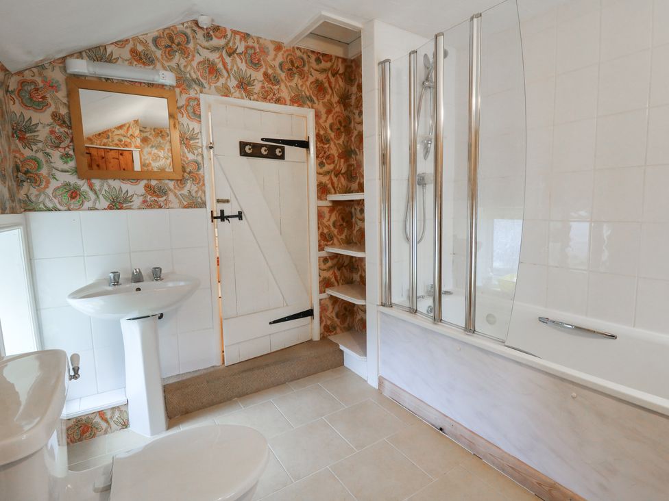A bathroom with a sink, toilet, bathtub and shower at 6 Church Lane in Llanidloes