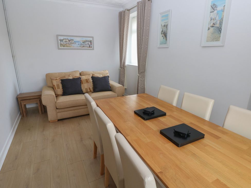 A dining room with a table and chairs at Brynawel in Burry Port