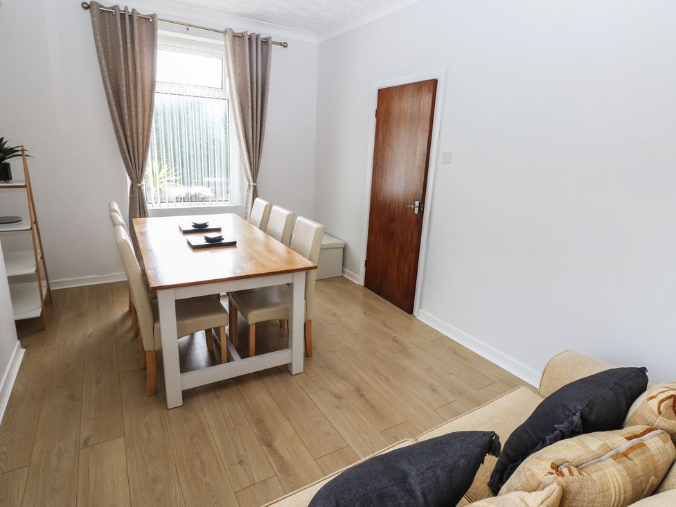 A dining room with a table and chairs at Brynawel in Burry Port