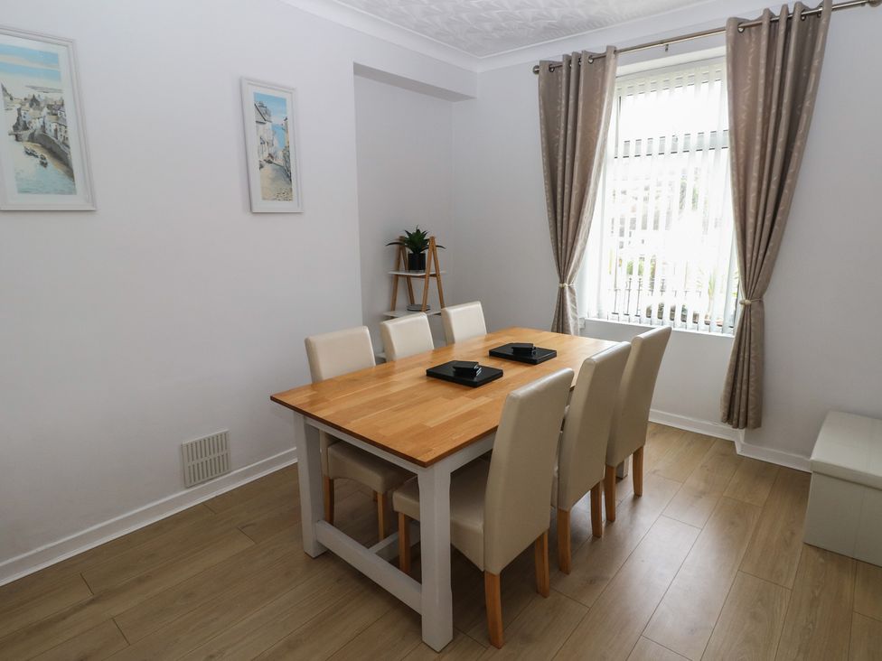 A dining room with a table and chairs at Brynawel in Burry Port