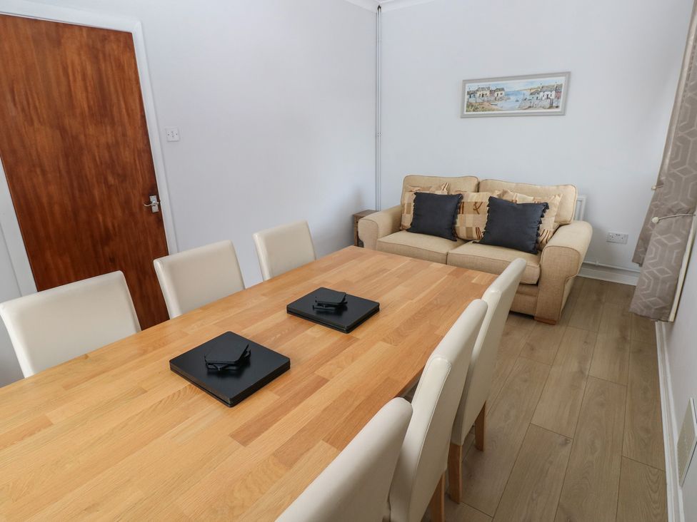A dining room with a table and chairs at Brynawel in Burry Port
