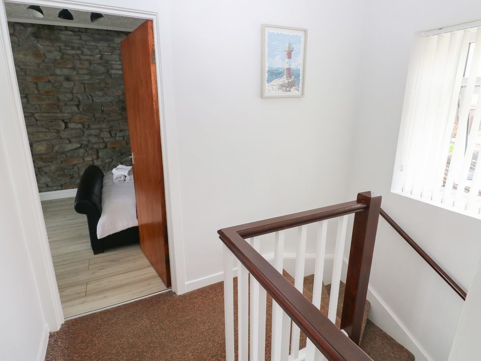 A staircase with door leading to a bedroom at Brynawel in Burry Port