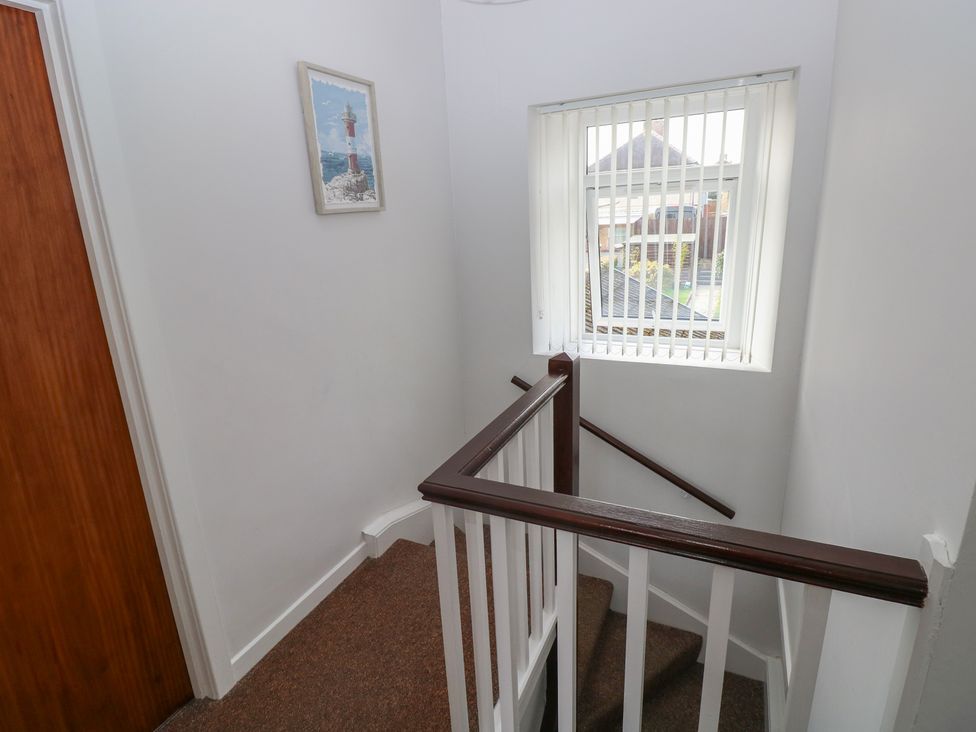 A staircase landing with a window and wall art at Brynawel in Burry Port