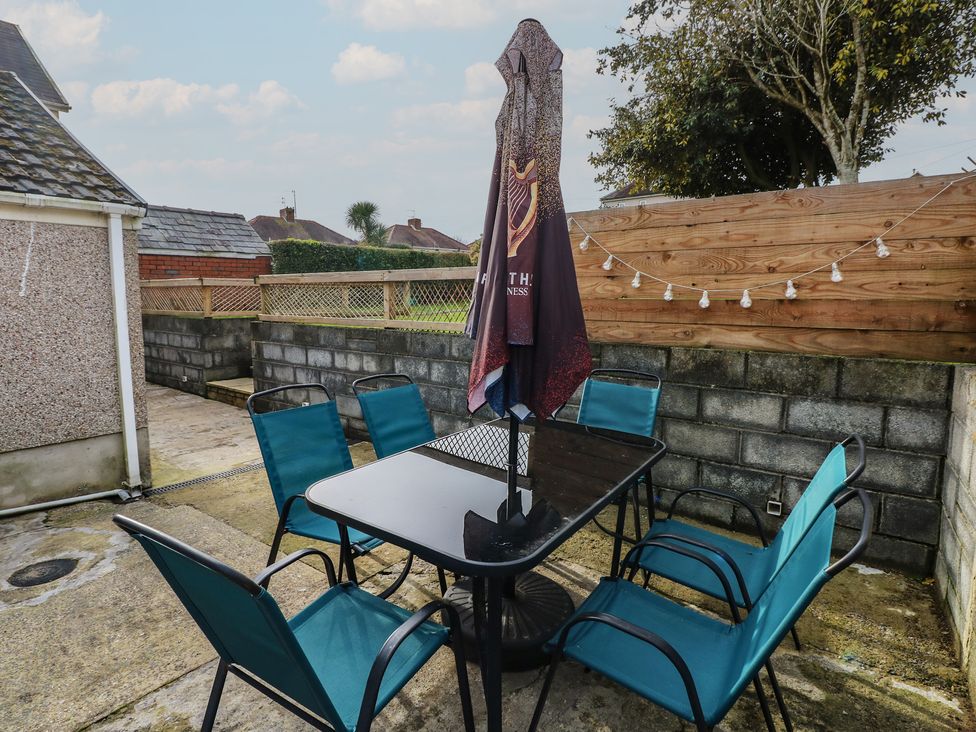 An outdoor seating area with a table and chairs at Brynawel in Burry Port