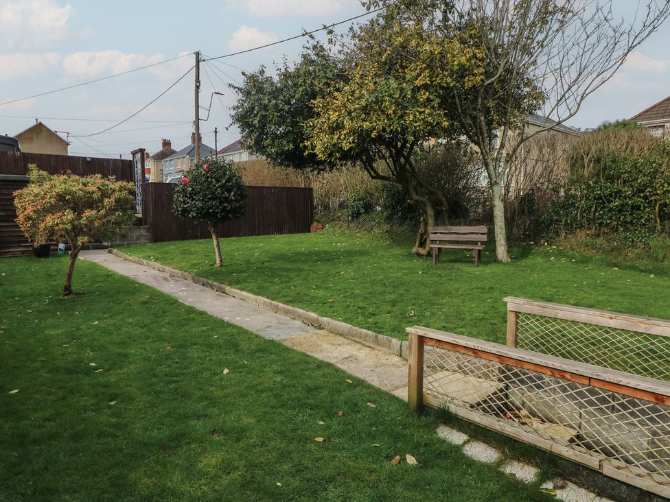 A garden with a path and bench at Brynawel in Burry Port