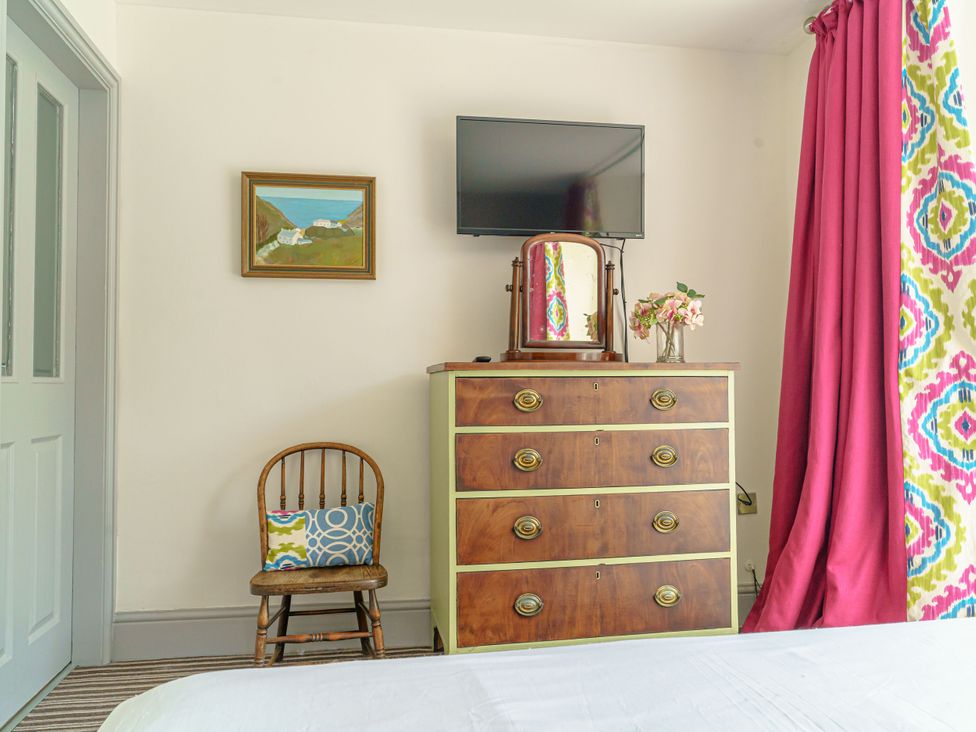 A bedroom with a dresser and a chair at Y Graiglwyd in Bull Bay near Amlwch