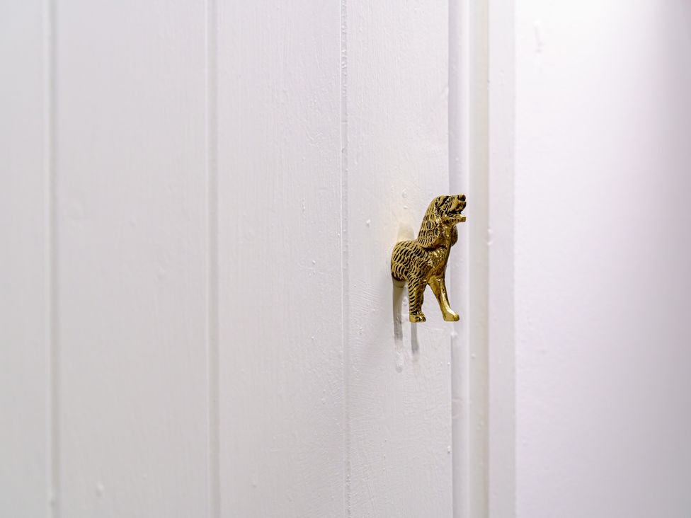 A decorative door knob in the shape of a dog on a white wall at Y Graiglwyd Bull Bay near Amlwch