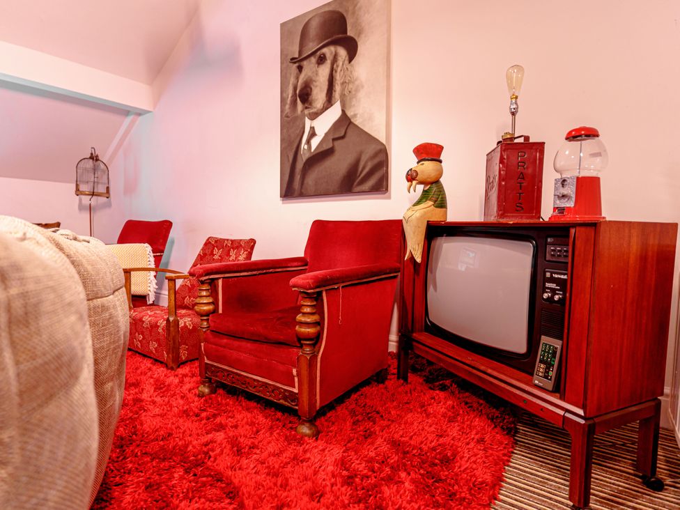 A living room with armchair and television at Y Graiglwyd Bull Bay near Amlwch