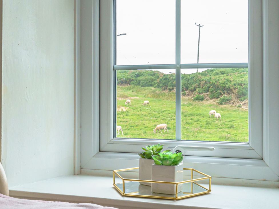 A window with a view of sheep grazing in a field at Y Graiglwyd Bull Bay near Amlwch