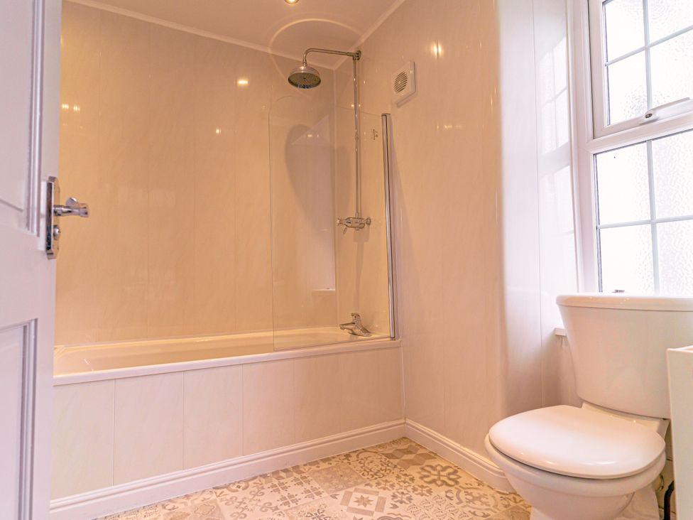 A bathroom with a bathtub and shower at Y Graiglwyd Bull Bay near Amlwch