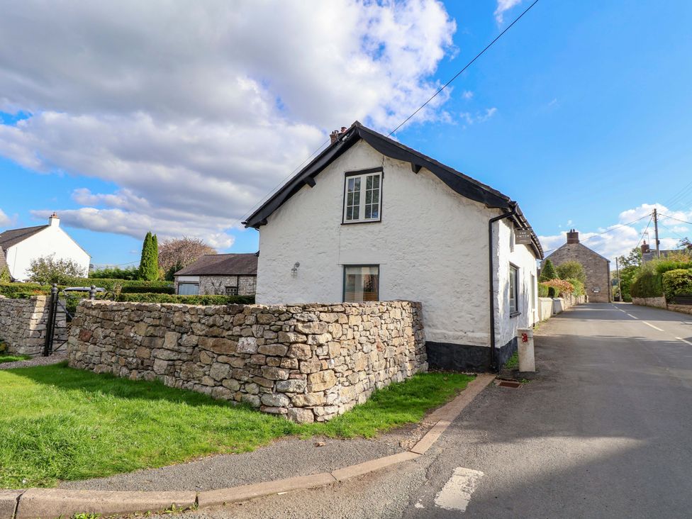 A house with a stone wall on the side at Cwtch in Mold