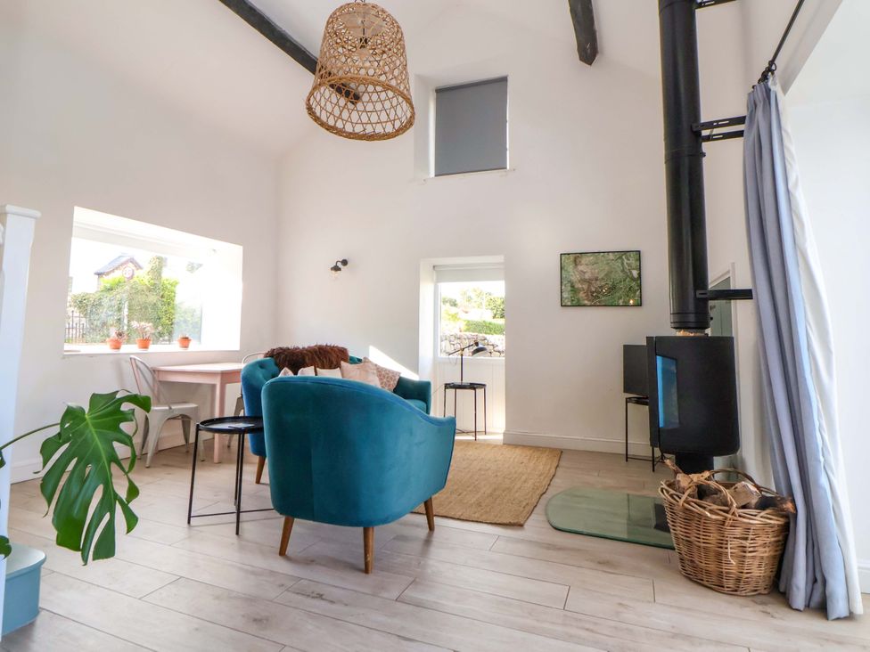 A living room with a sofa and table at Cwtch in Mold