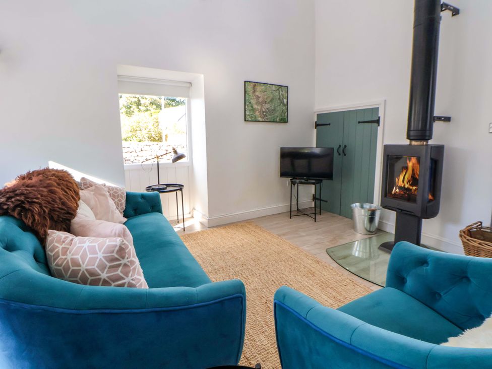 A living room with a fireplace and sofa at Cwtch in Mold