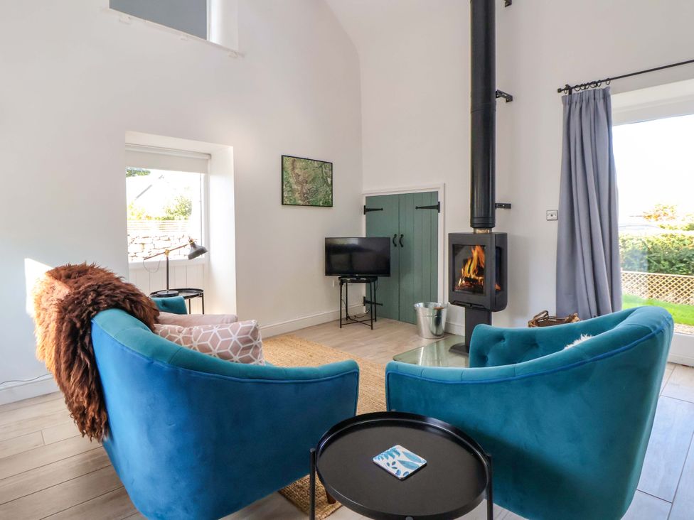 A living room with a fireplace and sofa at Cwtch in Mold