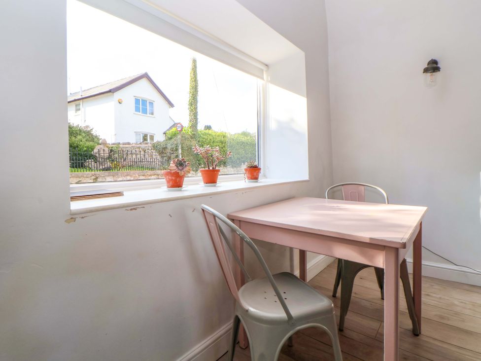 A dining area with a table and chairs at Cwtch in Mold