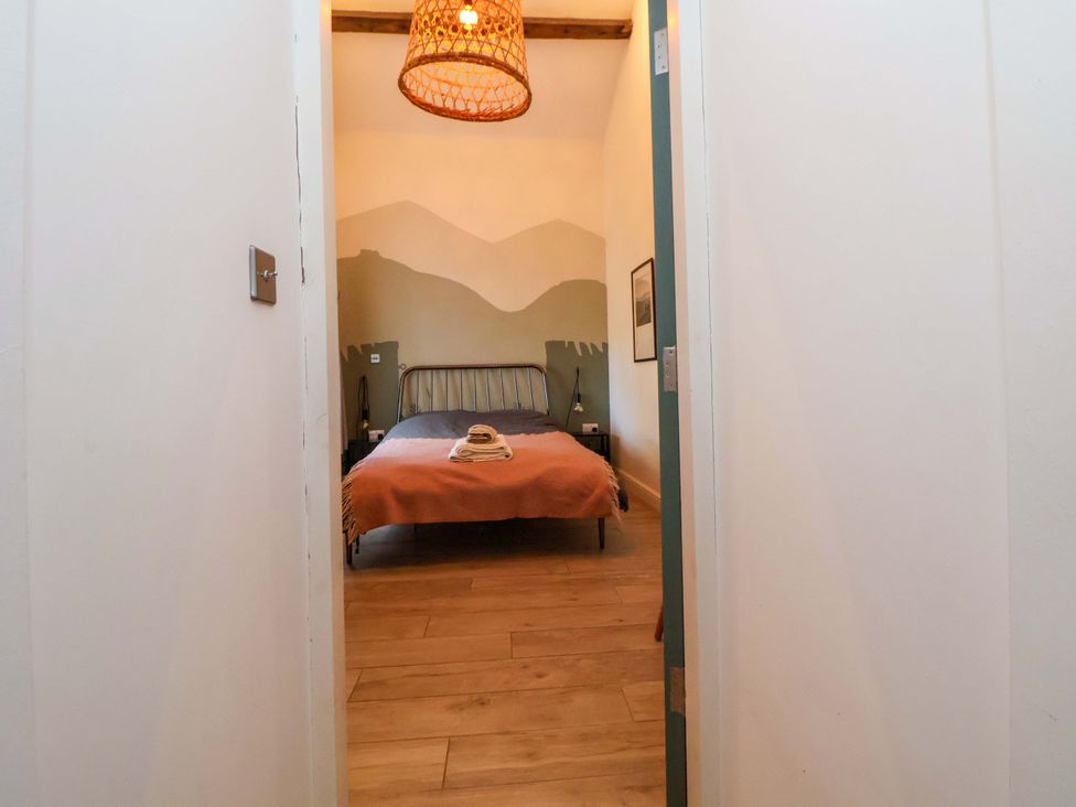 A bedroom with a bed and bedside table at Cwtch in Mold