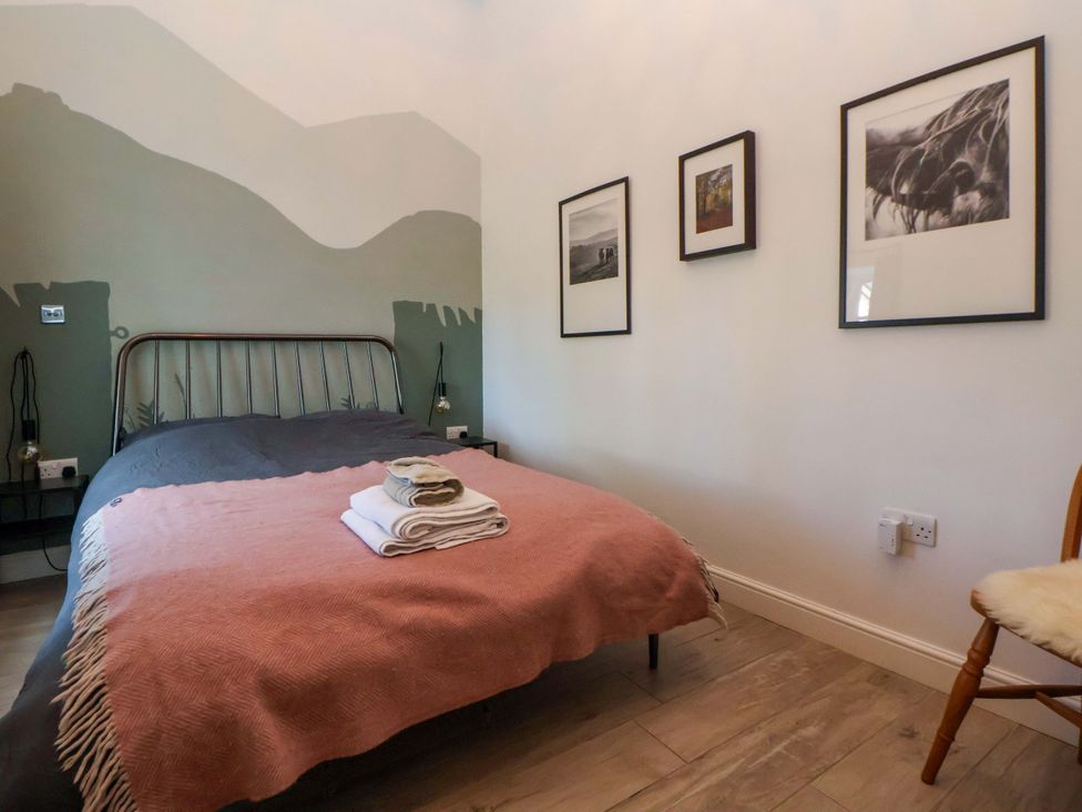 A bedroom with a bed and pictures on the wall at Cwtch in Mold
