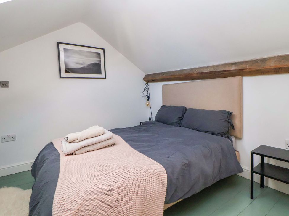 A bedroom with a bed and a picture hanging on the wall at Cwtch in Mold